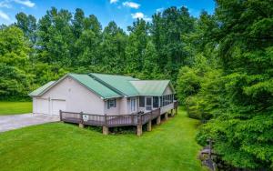 ein Haus mit einem grünen Dach auf einem Hof in der Unterkunft Hen Wallow Creek Cottage in Cosby
