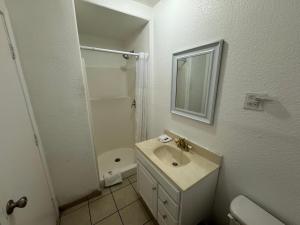 a white bathroom with a sink and a shower at Western Motel in El Centro +14 photos