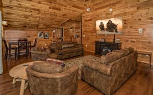 ein Wohnzimmer mit Möbeln und einem Kamin in einer Blockhütte in der Unterkunft Beartastic Mountain View Lodge in Gatlinburg