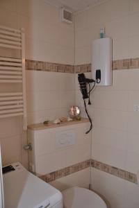 a bathroom with a toilet and a phone on the wall at Ferienwohnung Marina Wendtorf App. 6110 in Wendtorf
