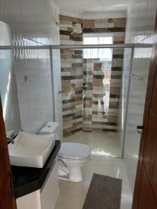 a bathroom with a white toilet and a sink at Minha casa, sua casa in Porto Seguro