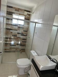 a bathroom with a toilet and a sink at Minha casa, sua casa in Porto Seguro