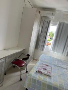 a bedroom with a bed and a desk and a chair at Minha casa, sua casa in Porto Seguro