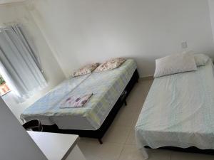 a bedroom with two beds and a window at Minha casa, sua casa in Porto Seguro