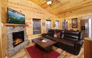 een woonkamer met een leren bank en een open haard bij Mountain Life in Sevierville