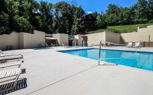 een groot zwembad met stoelen naast een gebouw bij Mountain Life in Sevierville