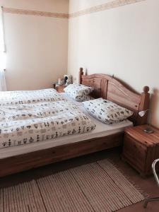 ein Schlafzimmer mit einem großen Holzbett mit zwei Kissen in der Unterkunft Pension Lindenhof in Limburg an der Lahn