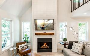 a living room with a fireplace with a tv above it at Farmhouse in the Burg in Gatlinburg