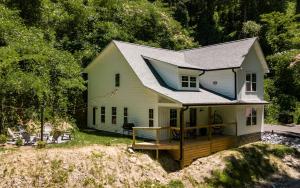 a small white house with a deck in the yard at Farmhouse in the Burg in Gatlinburg