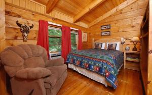 a bedroom with a bed and a chair in a cabin at Holden On in Pigeon Forge