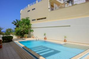 a swimming pool in front of a building at Aelória Boutique Suites in Agios Nikolaos