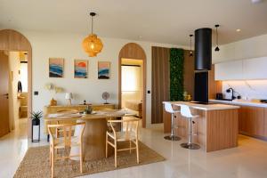 a kitchen with a table and chairs and a counter at Aelória Boutique Suites in Agios Nikolaos