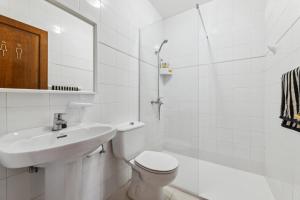 Un baño blanco con lavabo e inodoro. en Habitaciónes cerca de la playa y del aeropuerto en una casa familiar, en Playa Honda