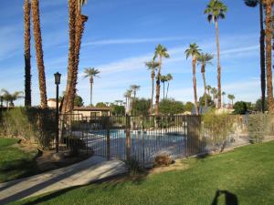 a fence around a pool with palm trees at Relaxing Rancho Mirage home inside Sunrise Country Club in Rancho Mirage +6 photos
