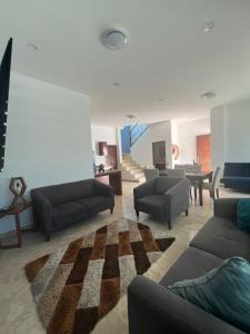 un ampio soggiorno con divani e un tappeto di Tacho's House privacy comfort 5 luxury a La Paz