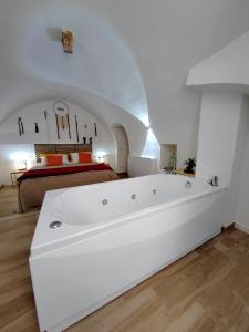 a white bath tub in a room with a bed at La Chianca Jacuzzi & Stone - Cozy Apartment - Conversano in Conversano