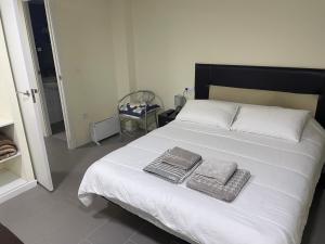 a bedroom with a white bed with two towels on it at Pontevedra Centro adosado in Pontevedra