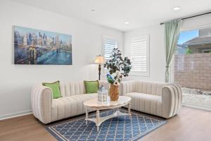 a living room with a couch and a table at Spacious 5BR Getaway w Game Room & Modern Comfort in Fontana