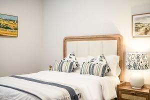 a bedroom with a large white bed with pillows at Spacious 5BR Getaway w Game Room & Modern Comfort in Fontana