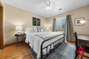 The Rose Garden Estate with Swim Spa - an Irvie Home في ألباكيركي: غرفة نوم مع سرير مع مروحة سقف ونافذة +68 صورة