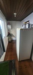 a kitchen with a white refrigerator and a wooden floor at Pousadas JC 2 AP completo in Santarém