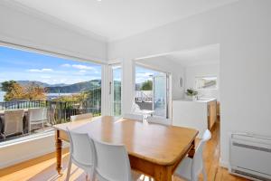 una sala da pranzo con tavolo e sedie e una grande finestra di Spacious Sunny Family Home in Akaroa ad Akaroa