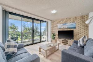 a living room with two blue couches and a tv at Tasman Towers 5 3 Munster Street in Port Macquarie