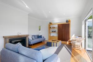un soggiorno con 2 divani blu e un camino di Spacious Sunny Family Home in Akaroa ad Akaroa