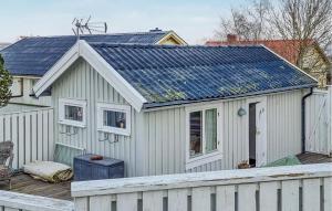 a house with a solar roof with a white fence at Lovely Home In Hönö With Harbor View in Hönö