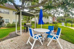 a table and chairs with a blue umbrella and a grill at Less Than half Mi to Coast New Smyrna Beach Getaway in New Smyrna Beach