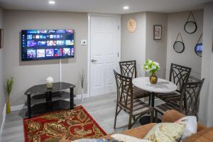 カルガリーにあるModern 2-Bedroom Suite with Private Access - 10 minutes from Calgary Airportのテーブルと椅子とテレビのあるリビングルーム