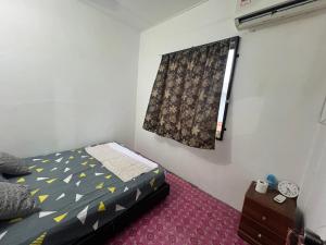 a small bedroom with a bed and a window at Homestay Townvilla Sibujaya Unit 6 in Sibu
