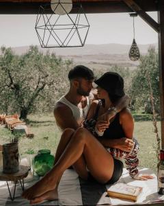 Un uomo e una donna seduti su un tavolo di Glamping la lodola a Crocina
