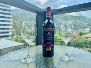 a bottle of wine sitting on a table with two wine glasses at Gonio Studio in Batumi in Kvariati