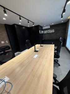 a conference room with a long wooden table and chairs at Stay Santos - Moderno e Bem Localizado in Santos +39 photos