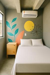a bedroom with a bed and a wall with flowers at Joy Hostel & Suítes in Brasilia