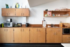 a kitchen with wooden cabinets and a microwave at Inner-City Townhouse with Free Parking & WiFi in Launceston +34 photos