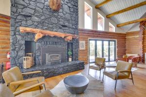 a living room with a stone fireplace and chairs at Red Hawk Ridge SD Mag Design Winner in Alpine