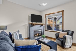 ein Wohnzimmer mit Couch und Kamin in der Unterkunft Peaks and Patio 3 Bedroom managed by Little Sister Getaways in Canmore
