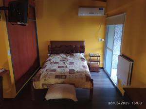 1 dormitorio con 1 cama en una pared amarilla en Casa de Nico, en Buenos Aires