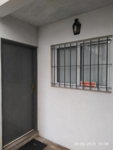 una puerta y una ventana en una pared blanca en Casa de Nico, en Buenos Aires