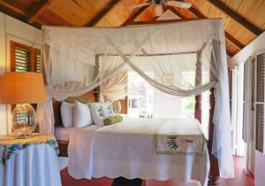 - une chambre avec un lit à baldaquin et un plafond en bois dans l'établissement Hermitage Nevis, à Nevis