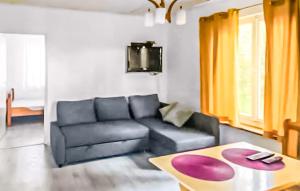 a living room with a black couch and a table at 1 Bedroom Lovely Home In Kamionki Male in Kamionki Małe +2 photos