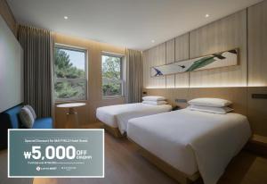 two beds in a hotel room with a price sign at Mayfield Hotel Seoul in Seoul