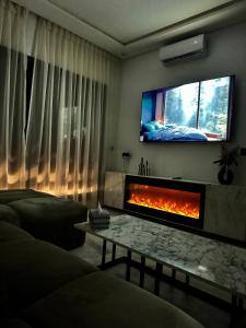 a living room with a fireplace and a tv at Cocoon in Gueliz, Netflix, IPTV in Marrakech