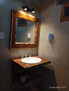 a bathroom with a sink and a mirror at Cabañas El Alemán 2 in Cerrillos