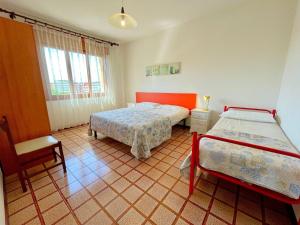 a bedroom with two beds and a chair in it at Apartment in Porto Santa Margherita by Beach in Porto Santa Margherita di Caorle
