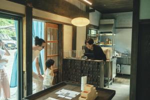 a woman and a woman and a child in a kitchen at ame nakasendo - A 150 years old private kominka along the Nakasendo trail - in Nagiso