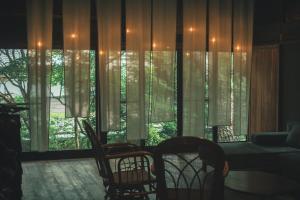 a living room with a window with curtains and chairs at ame nakasendo - A 150 years old private kominka along the Nakasendo trail - in Nagiso