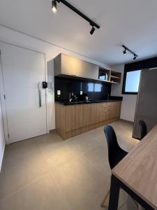 a kitchen with a table and a chair in a room at Santos Comfort - Perto da Praia in Santos